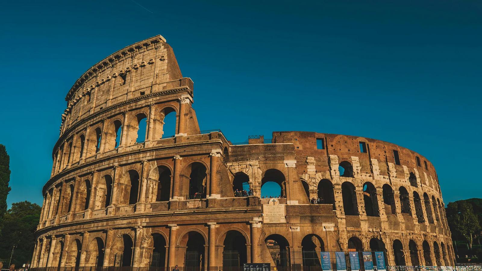 Aerial view of the Colosseum and Rome in warm evening light