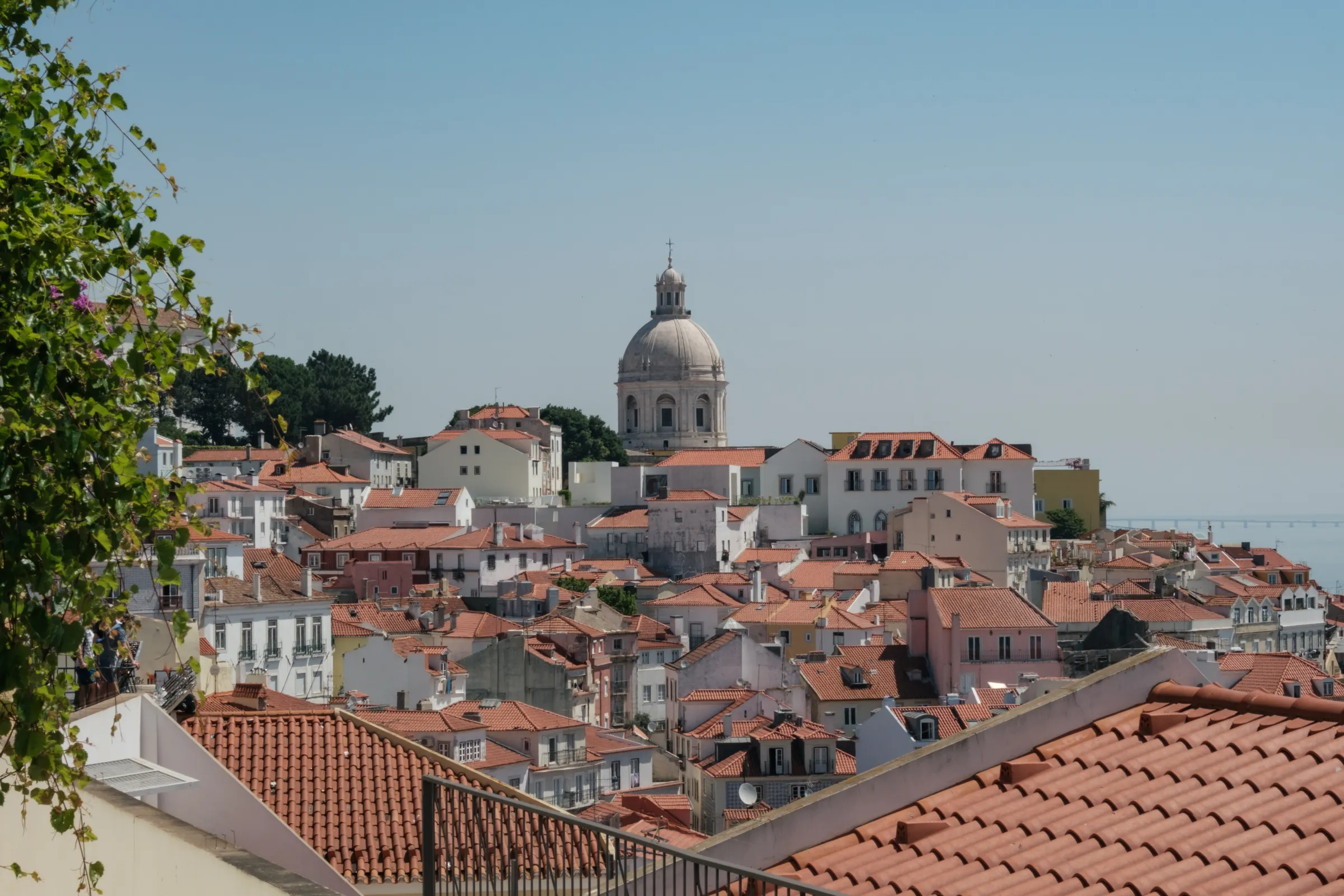 Sunlit terracotta rooftops and church dome in Lisbon