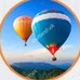 Hot air balloons drifting over a valley