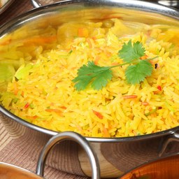 A bowl of golden rice garnished with fresh coriander